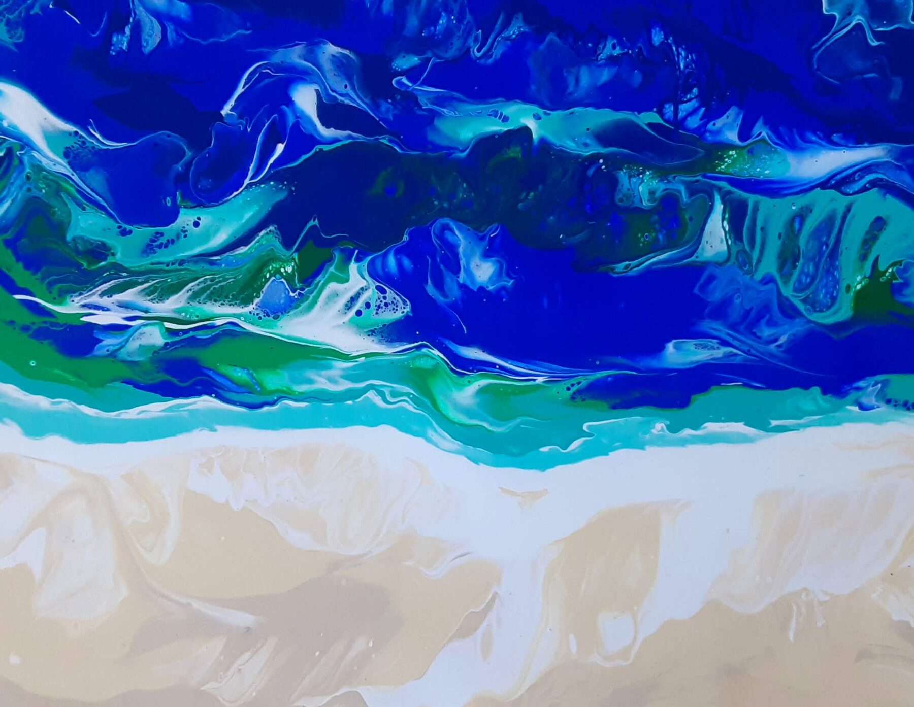 Deep blue poured water breaking over a wide pale shore