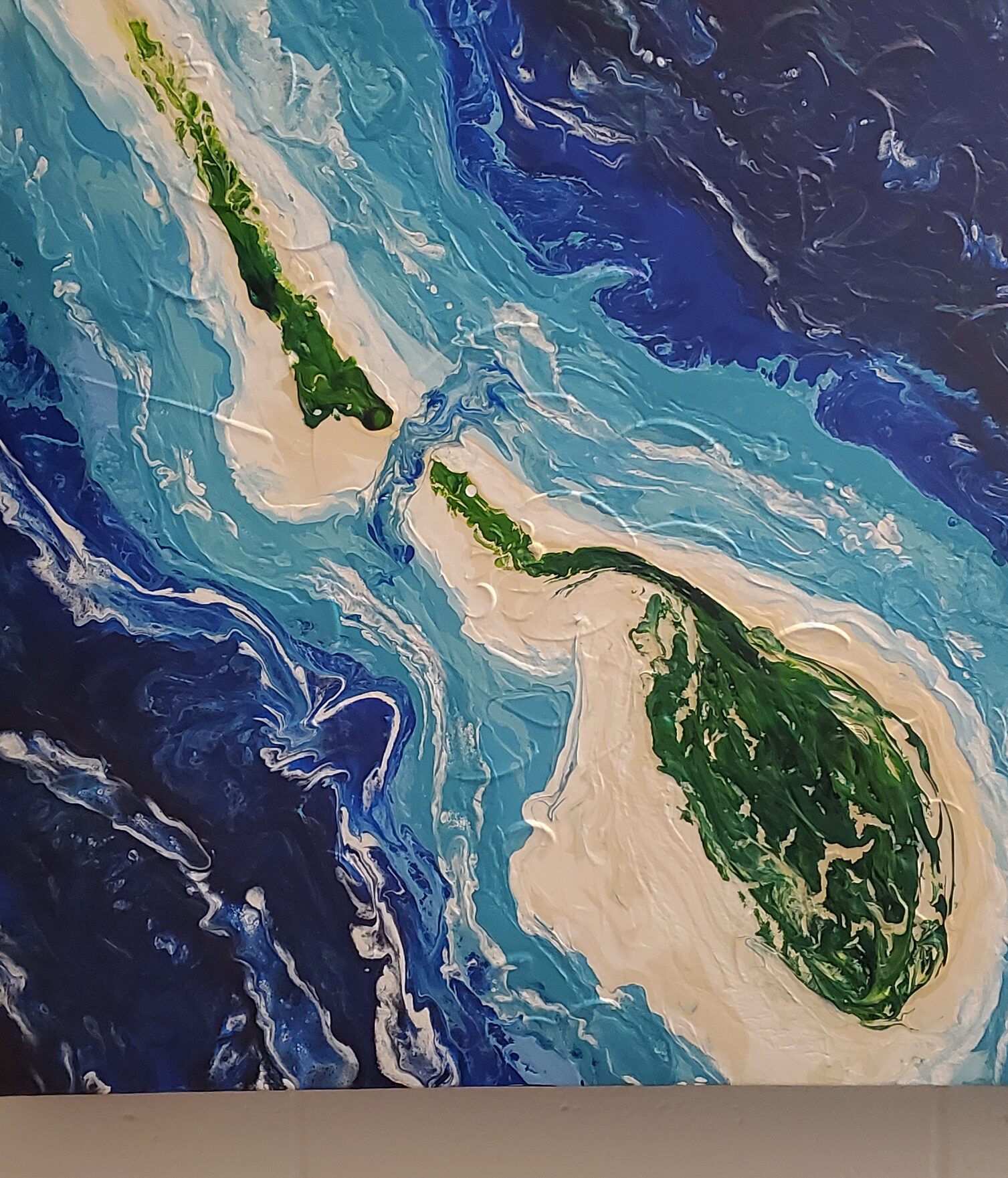 Poured deep blue water around two green islands seen from above